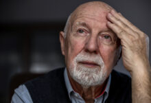 Portrait of a senior man suffering from a headache