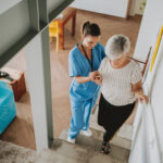 Nurse helping an elderly woman walking down the stairs