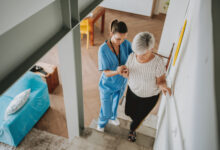 Nurse helping an elderly woman walking down the stairs