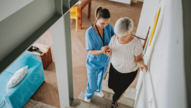 Nurse helping an elderly woman walking down the stairs