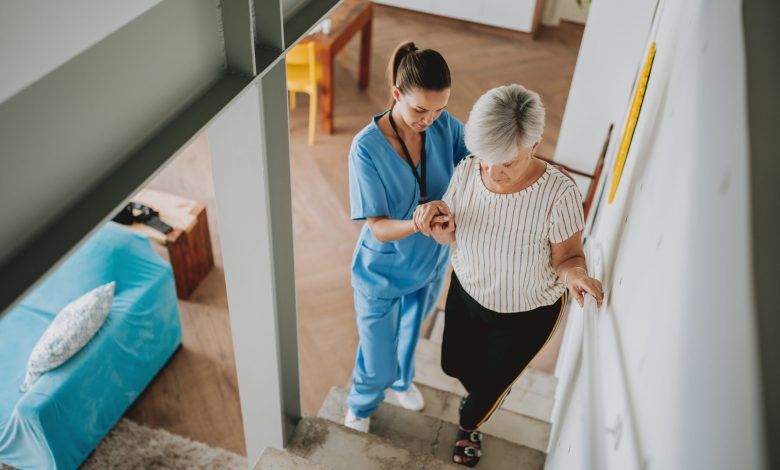 Nurse helping an elderly woman walking down the stairs