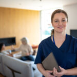 Portrait of nurse with a stethoscope at the patient's home. The Nurse looks at the camera