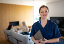 Portrait of nurse with a stethoscope at the patient's home. The Nurse looks at the camera