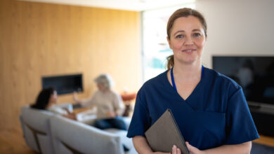 Portrait of nurse with a stethoscope at the patient's home. The Nurse looks at the camera