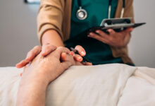 Unrecognizable young female doctor comforting unrecognizable older female patient