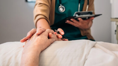 Unrecognizable young female doctor comforting unrecognizable older female patient