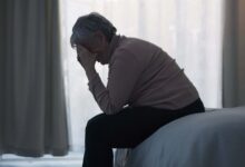 Stress, depression and sad old woman in bedroom with anxiety, mental health problem and debt in retirement. Lonely senior female person crying at home for headache, pain and fatigue of crisis in mind