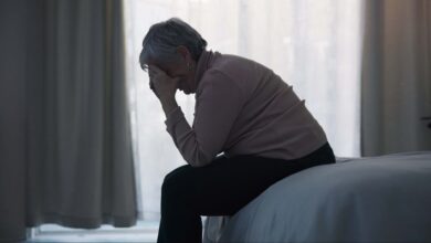 Stress, depression and sad old woman in bedroom with anxiety, mental health problem and debt in retirement. Lonely senior female person crying at home for headache, pain and fatigue of crisis in mind