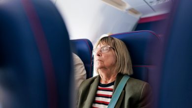 Senior woman travelling by plane. She is sleeping.