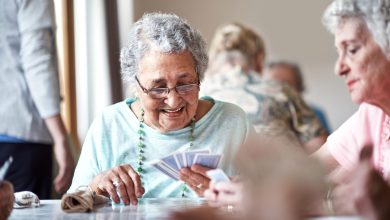 Shot of a group of seniors playing a board game in their retirement home