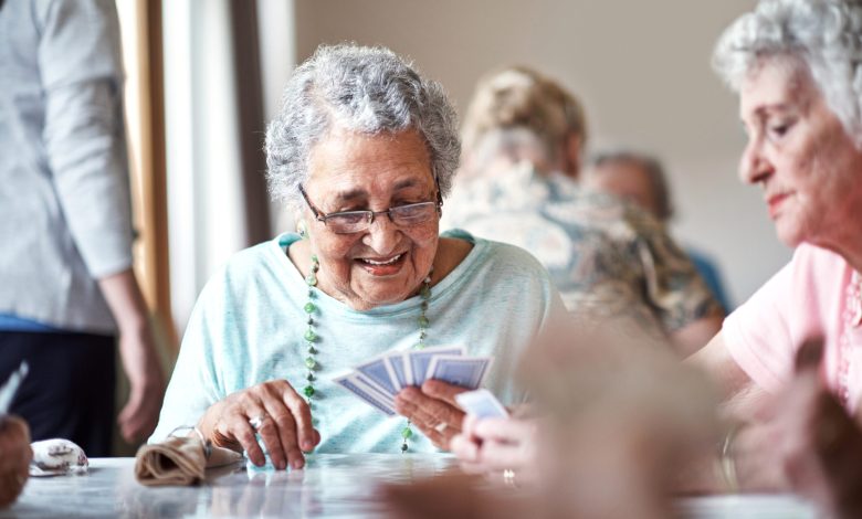 Shot of a group of seniors playing a board game in their retirement home