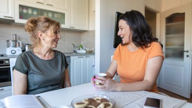 Mother and daughter sitting at a table and talking