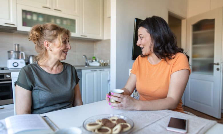 Mother and daughter sitting at a table and talking