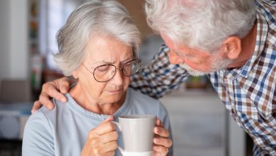 Old senior man comforting his depressed illness wife, unhappy elderly woman at home need medical help.