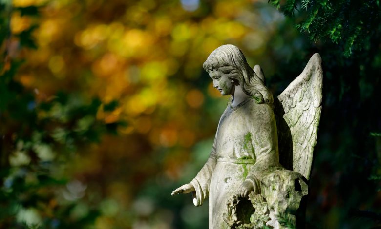 Weathered stone sculpture of an angel in a cemetery