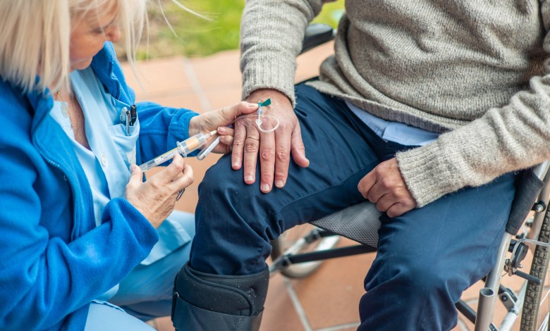 Nurse administering an injection to a senior adult in a wheelchair, highlighting compassion and the importance of support in elderly care