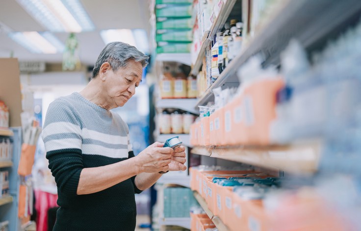 asian chinese senior man looking for medical supplies in drug store pharmacy shop