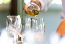 A waiter serves a glass of white wine