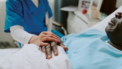 Nurse in scrubs holding hand of elderly patient. Scene portraying compassion, care, and medical support in a clinical setting, with healthcare services being rendered to a senior individual