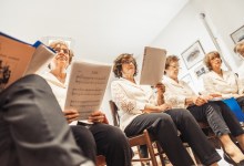 Senior Women Holding Music Sheets at Choir Practice.