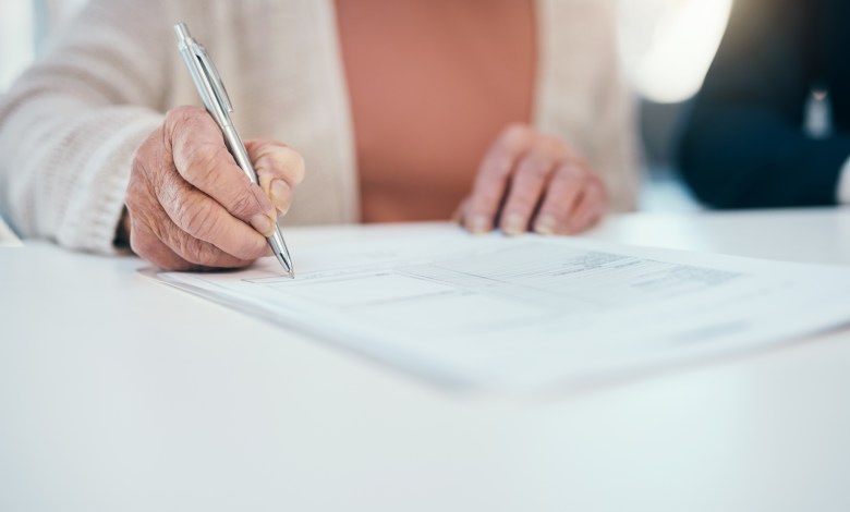 Senior hand signing finance paperwork, will agreement and pension fund contract while planning budget, banking and investing. Closeup of old, aged and retired woman calculating expenses and spending
