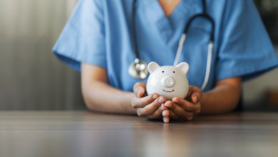 Nurse or doctor with stethoscope holding piggy bank in hand. Concept of medical expenses, finance, saving money, health insurance, medicine, donation and pension. Healthcare service cost.