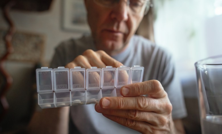 Man at home with pills organizer