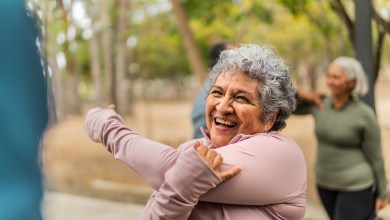 Senior woman stretching and talking friend at public park
