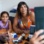 Young Aboriginal girl and her Grandmother consult with their Pacific Islander doctor about her ultrasound results in his office