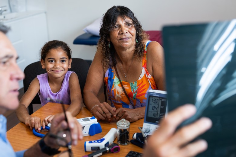 Young Aboriginal girl and her Grandmother consult with their Pacific Islander doctor about her ultrasound results in his office