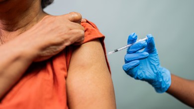 Close-up of a doctor's hand vaccinating a woman in a studio shot