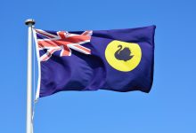Close-up of Western Australia flag in blue sky background.