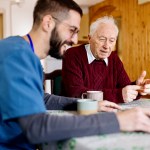 Home caretaker – man helping senior man